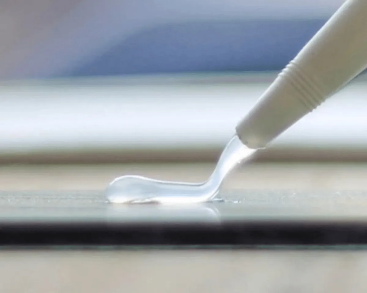 Industrial adhesive being applied to metal surface for sealing and bonding applications