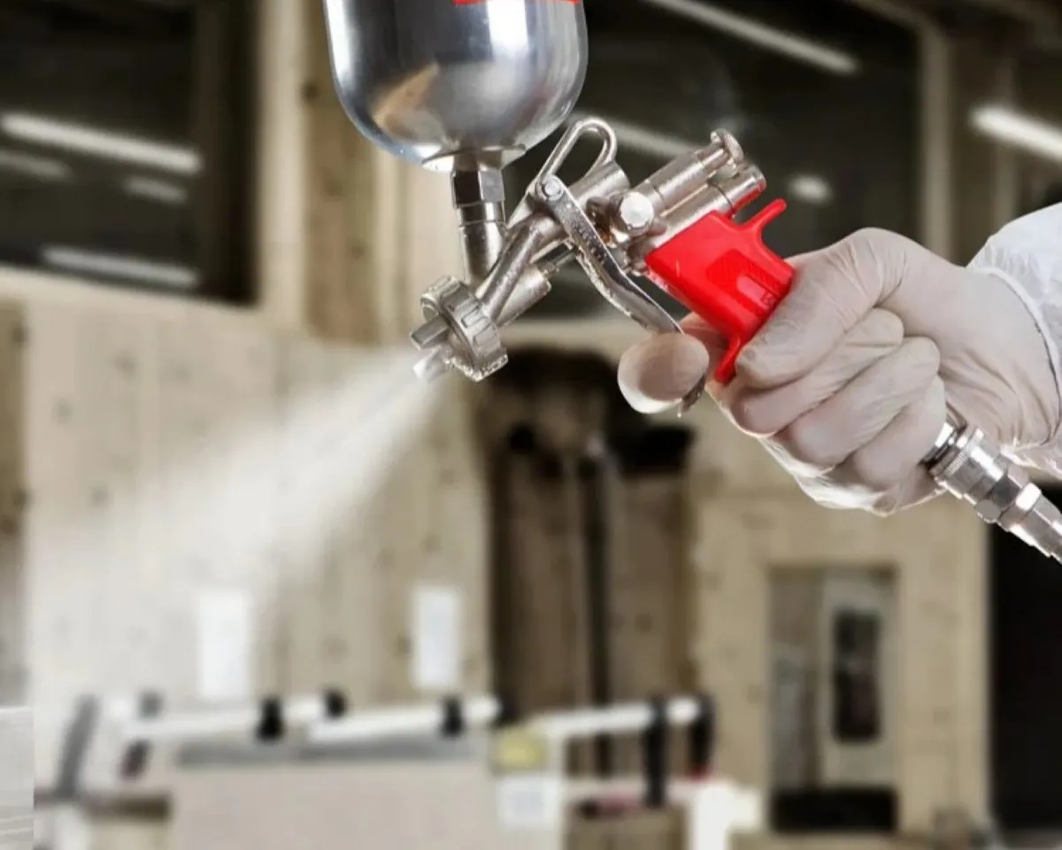 Industrial spray gun connected to air compressor for surface coating applications